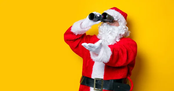 Funny Santa Claus holding binoculars — Stock Photo, Image