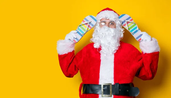 Zábavné Santa Claus drží flip flops — Stock fotografie