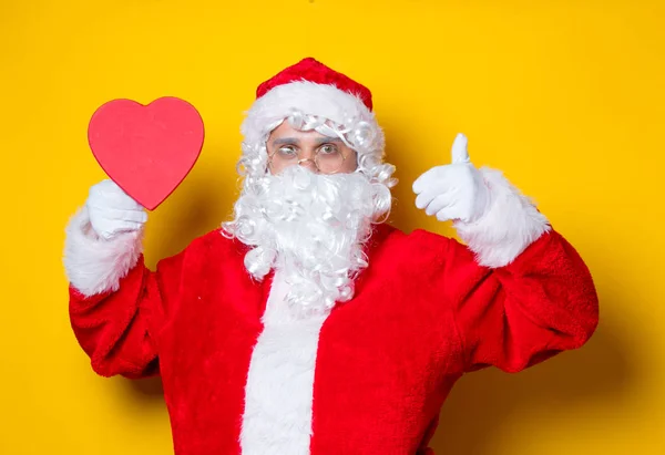 Weihnachtsmann mit herzförmigem Geschenk — Stockfoto