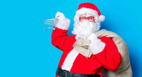 Lustige Weihnachtsmänner haben Spaß mit Einkaufswagen — Stockfoto