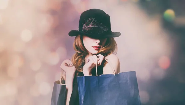 Mulher em vestido preto com sacos de compras — Fotografia de Stock