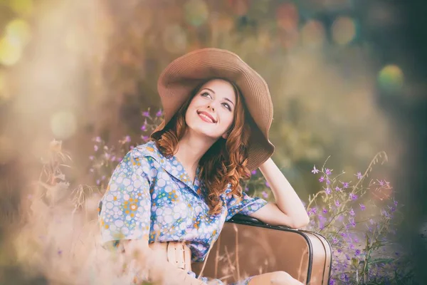 Vrouw met koffer in herfst park — Stockfoto