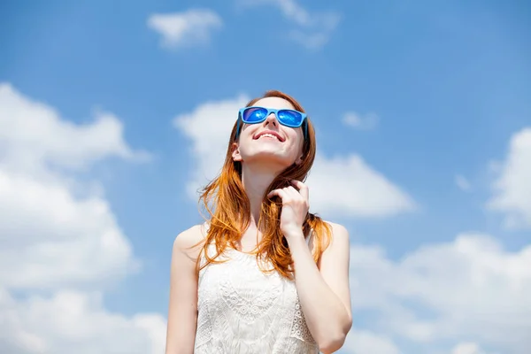 Roodharige meisje in blauwe zonnebril — Stockfoto