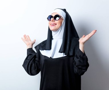 Bununla birlikte güneş gözlüklü genç gülümseyen Rahibe 