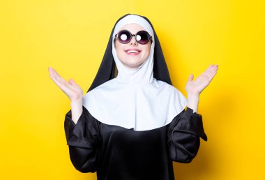 Bununla birlikte güneş gözlüklü genç mutlu Rahibe