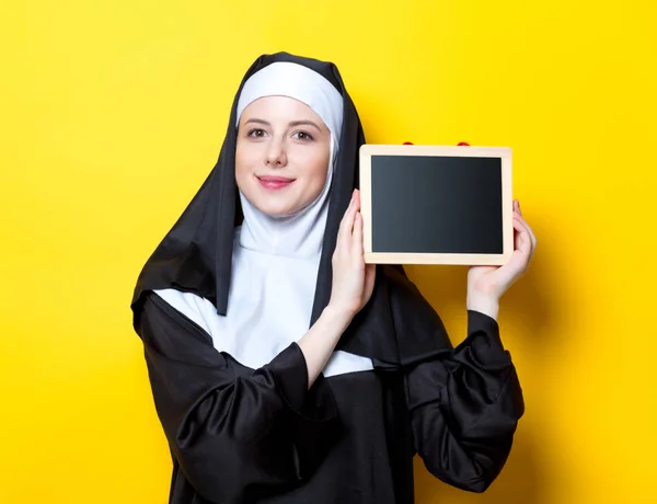 Jeune religieuse souriante avec planche — Photo