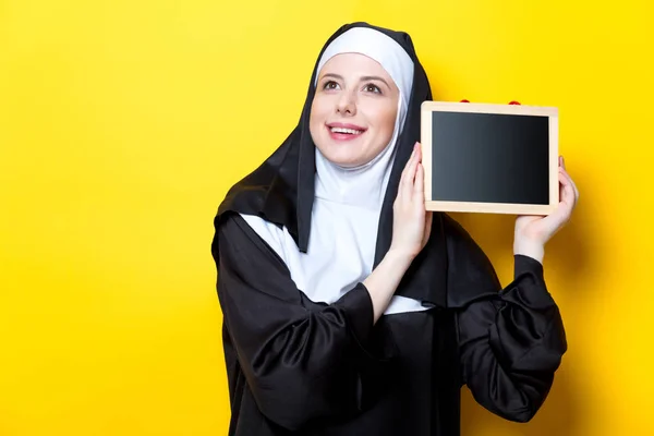 Jovem freira sorridente com bordo — Fotografia de Stock