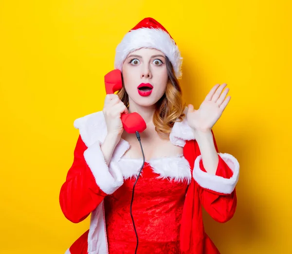 Santa dziewczyna w czerwone ubrania ze słuchawką — Zdjęcie stockowe