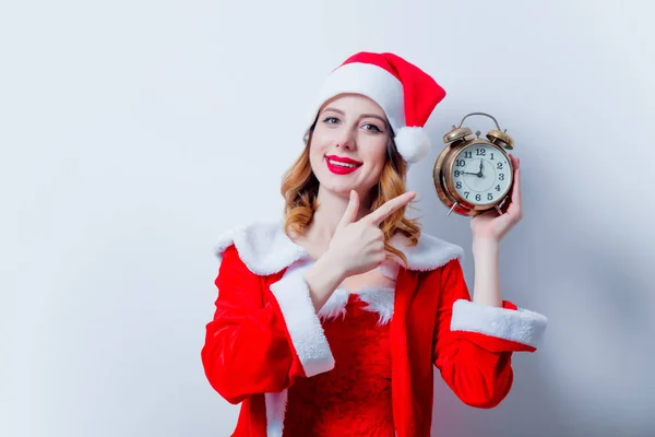 Santa chica en ropa roja con despertador —  Fotos de Stock