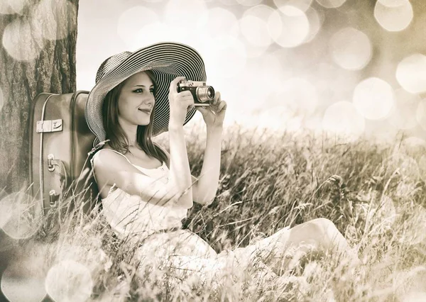 Donna seduta vicino all'albero con macchina fotografica — Foto Stock