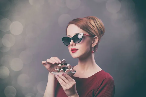 Mujer joven con caramelos de chocolate — Foto de Stock