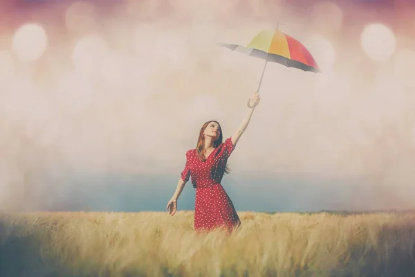 Jeune femme avec parapluie sur le champ de blé — Photo