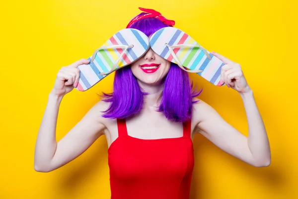Молодая женщина с разноцветными шлепанцами — стоковое фото