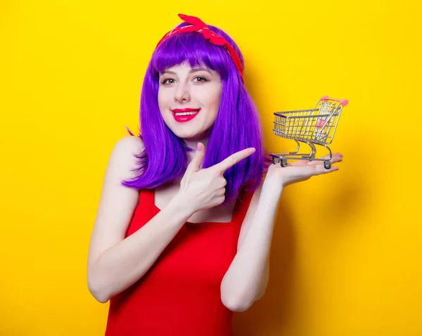 Giovane donna con piccolo carrello del supermercato — Foto Stock