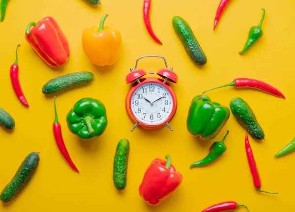 Rood alarm klok met komkommers en Spaanse peper — Stockfoto