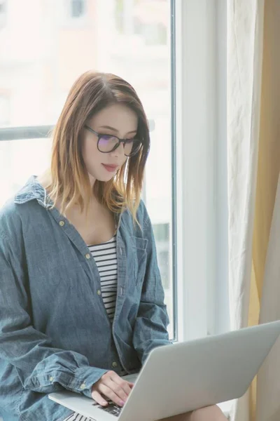 Giovane donna utilizzando il computer portatile — Foto Stock