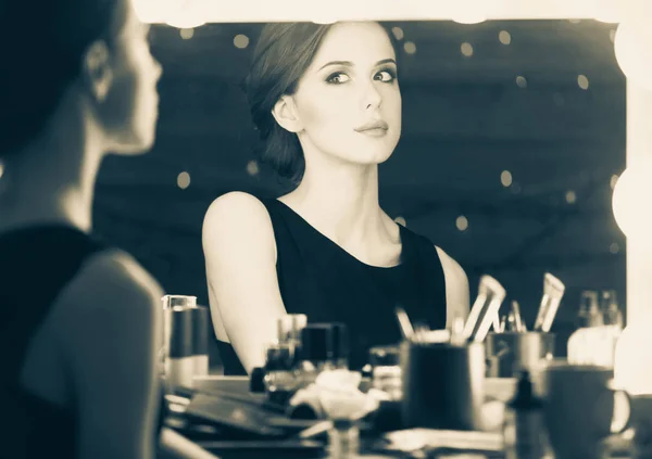 Красивая женщина у зеркала для макияжа — стоковое фото