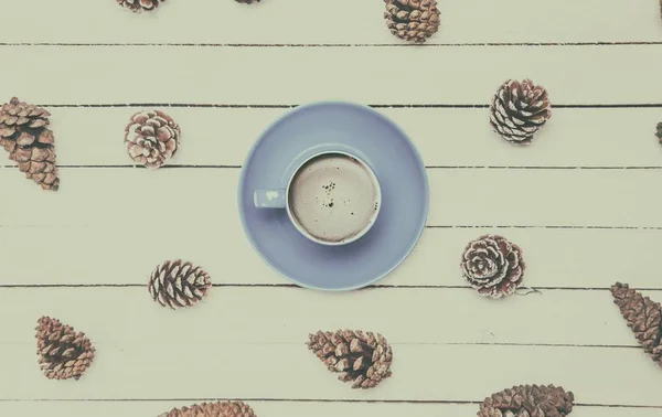 Cup of coffee and pine cones — Stock Photo, Image