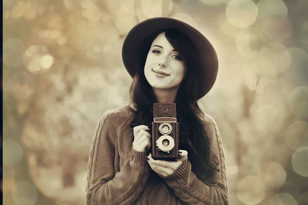Brunette meisje met camera in het park — Stockfoto