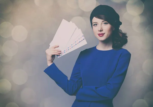 Vrouw in blauwe jurk met enveloppen — Stockfoto