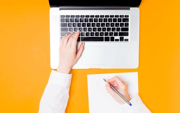 Businesswoman making notes with laptop — Stock Photo, Image