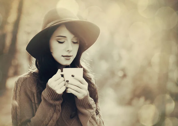Brunette girl with cup in the park — Stock Photo, Image