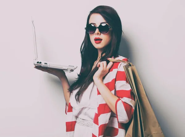 Mujer con bolsas de compras y portátil —  Fotos de Stock