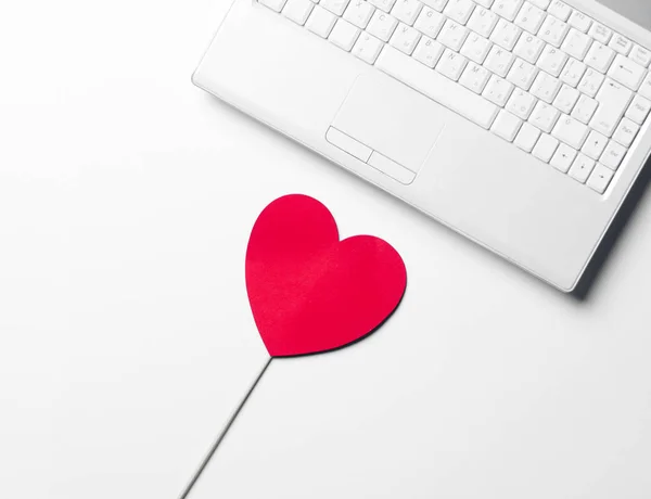 Игрушка в форме сердца и ноутбук — стоковое фото
