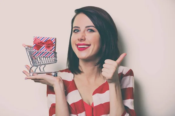 Donna con regalo e carrello — Foto Stock