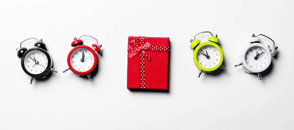 Piros ajándék és színes órák — Stock Fotó