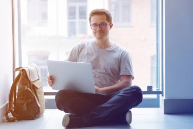 Katında dizüstü bilgisayar kullanan adam