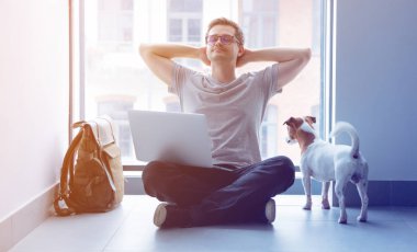 Genç adam dizüstü bilgisayar kullanıyor.