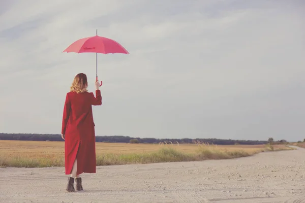 Žena s deštníkem v poli — Stock fotografie