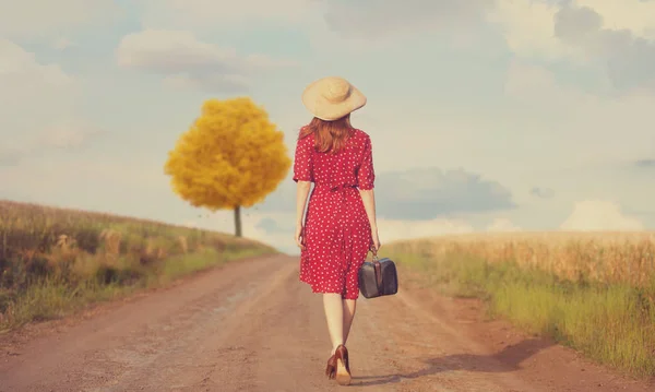 Рыжая девушка с чемоданом — стоковое фото