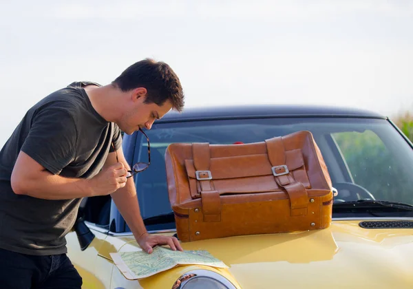 Young man with map and suitcase — Stock Photo, Image