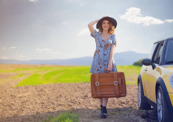 Harita ve bavul ile Kızıl saçlı kadın 