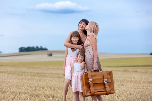 Мама, бабушка и девочки с чемоданом — стоковое фото
