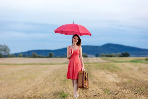 Femme avec valise et parapluie — Photo