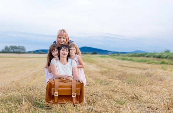 Madre, nonna e ragazze con valigia — Foto Stock