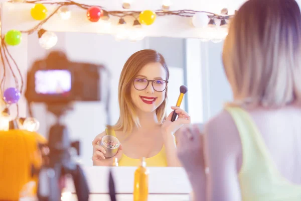 Mujer aplicando cosméticos en la cámara — Foto de Stock