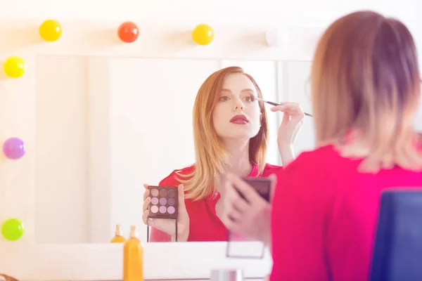 Mujer aplicando cosméticos en la cámara — Foto de Stock