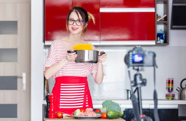 Mujer joven cocinando en cámara —  Fotos de Stock
