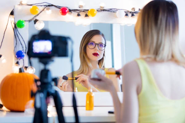 Mujer aplicando cosméticos en la cámara — Foto de Stock