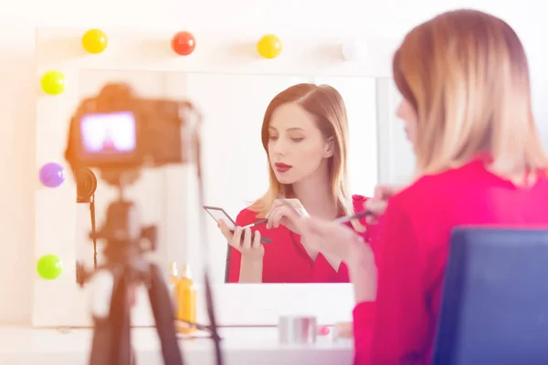 Mujer aplicando cosméticos en la cámara — Foto de Stock