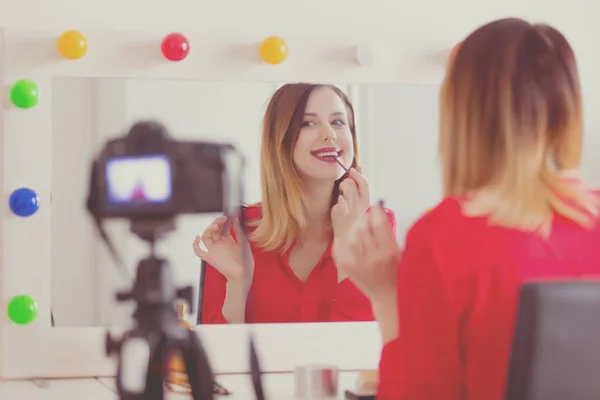 Vrouw toepassen van cosmetica op camera — Stockfoto