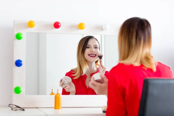 Woman applying cosmetics at camera — Stock Photo, Image