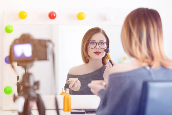 Mujer aplicando cosméticos en la cámara — Foto de Stock