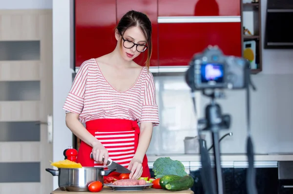 Giovane donna cucina a macchina fotografica — Foto Stock