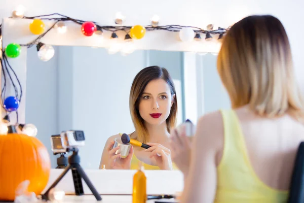 Mujer aplicando cosméticos en la cámara — Foto de Stock