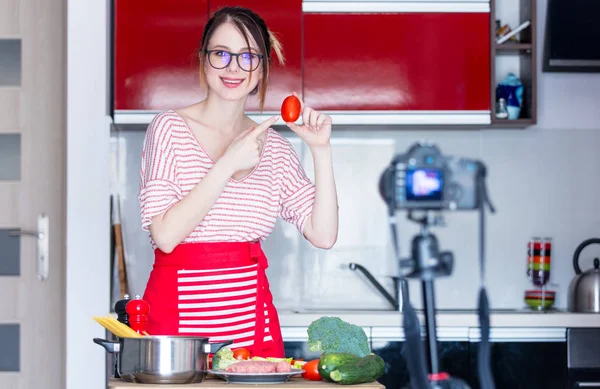 Giovane donna cucina a macchina fotografica — Foto Stock